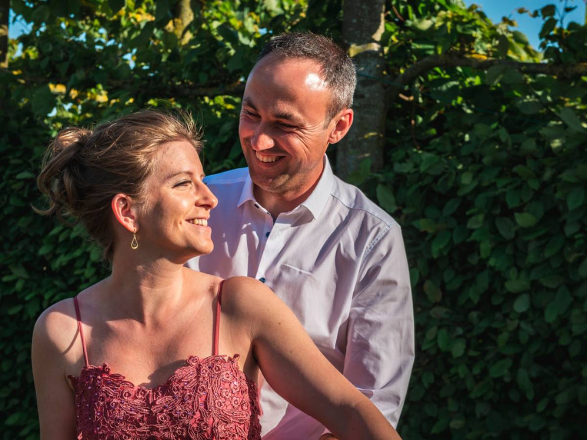 Un couple mature souriant et partageant un moment tendre en extérieur, illustrant la complicité et la solidité d’un amour célébré lors des noces de fer, 41 ans de mariage.